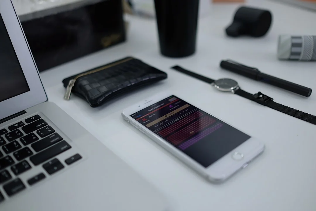 An iPhone with a journaling app open on a wooden desk next to a coffee cup