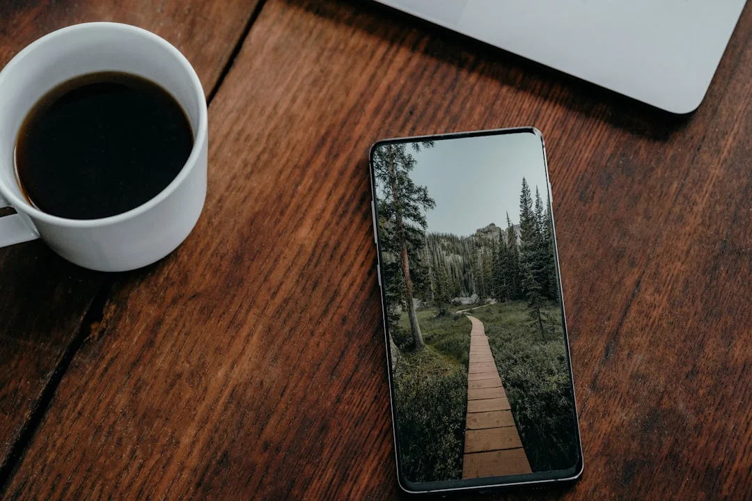 A phone on a wooden table showing a mental health app, next to a cup of coffee