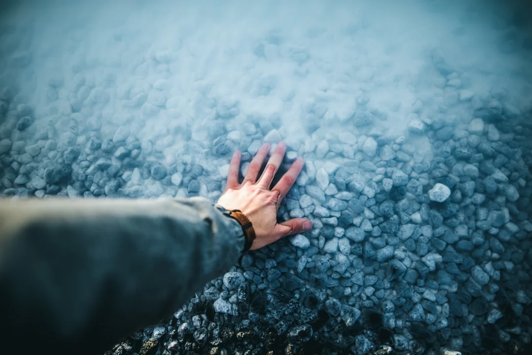 A hand resting on a stone surface, representing physical grounding during anxiety