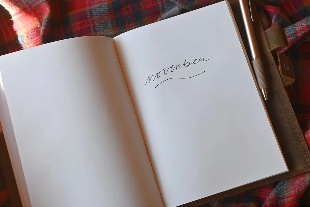 A person writing a single word in a journal by a window, representing emotion naming